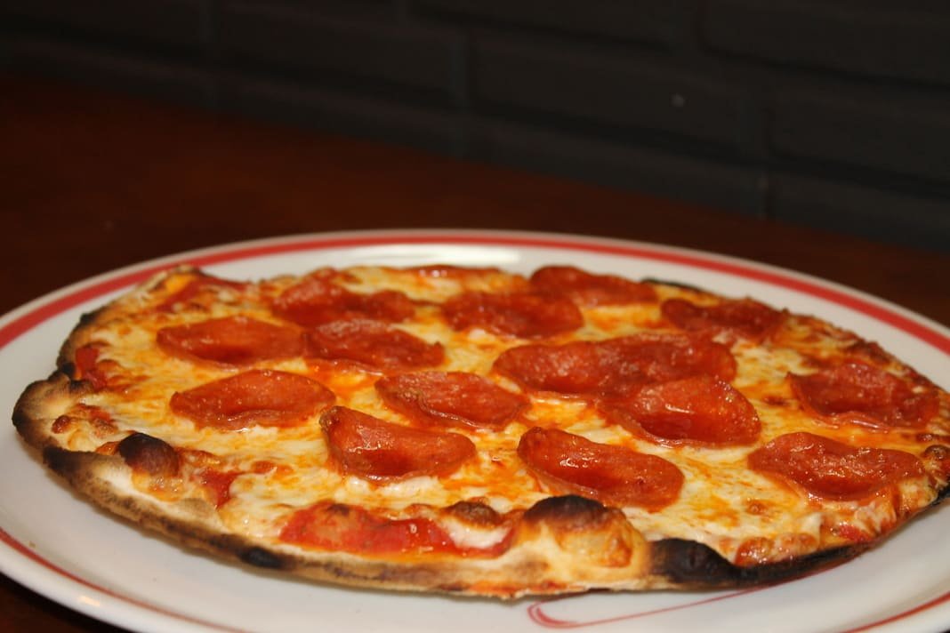 Pizza pepperoni con cebolla y aceite de ajo y perejil
