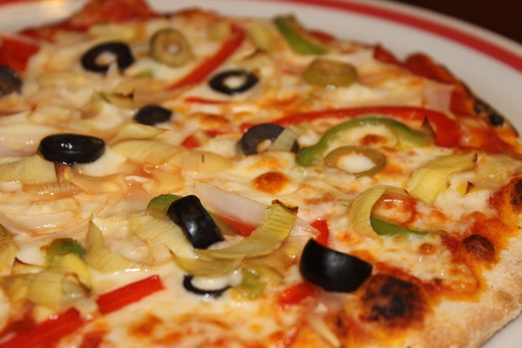 Pizza vegetariana con cebolla, aceitunas, champiñones y alcachofas