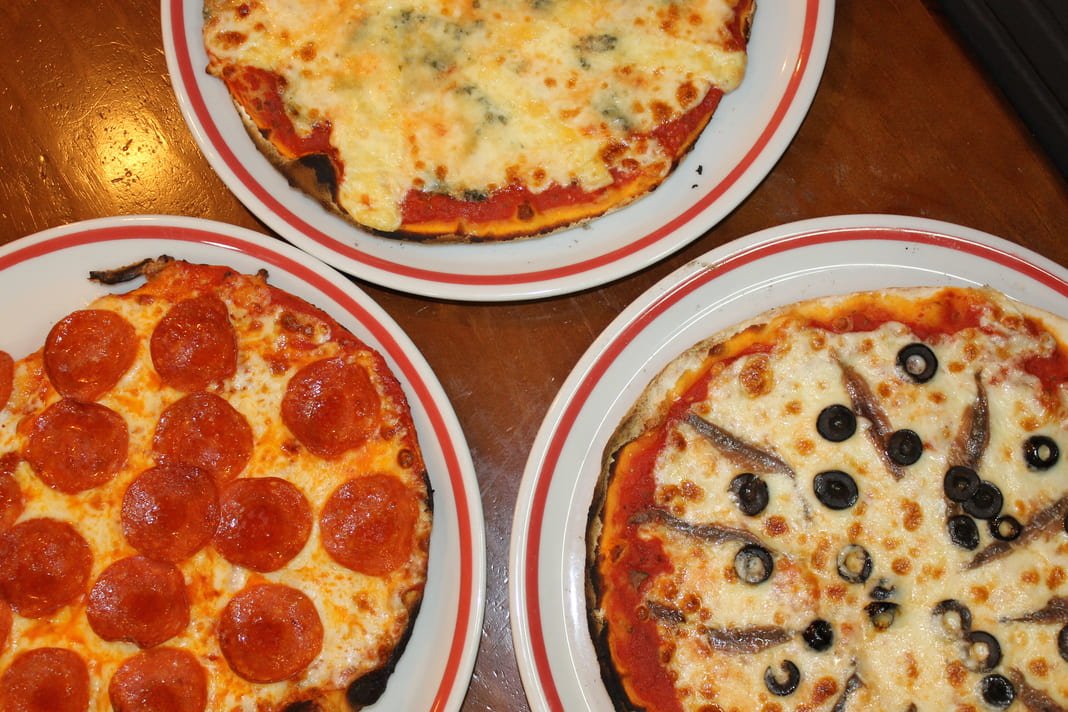 Conjunto de pizzas artesanales de Il Nuraghe sobre la mesa