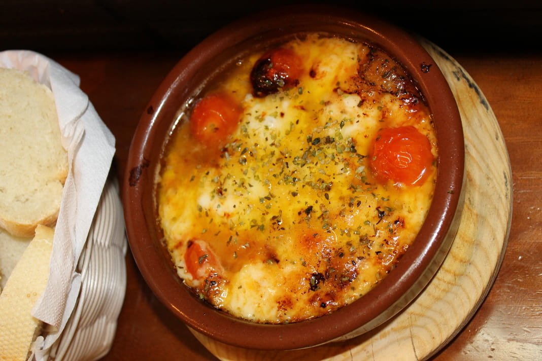 Provoleta de provolone fundido con tomates cherry y orégano