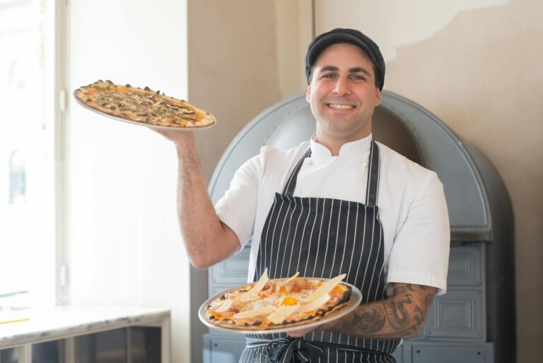 A cheerful chef presents delicious pizzas in a cozy pizzeria setting, showcasing culinary skills.