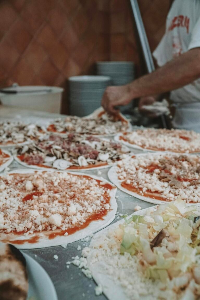 Authentic Italian pizzas being meticulously prepared in a Roman kitchen, showcasing fresh toppings.
